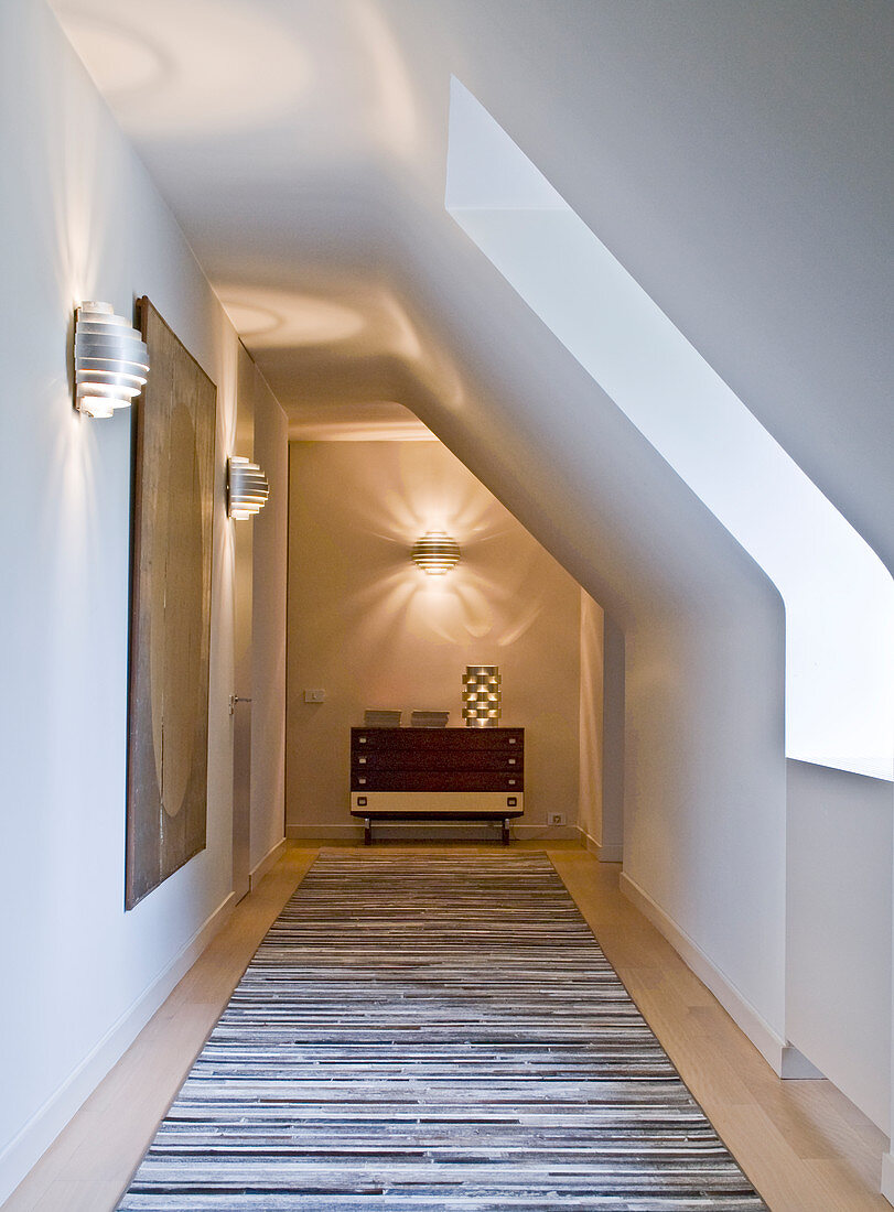 Wall sconces, painting, console table and floor runner in attic hallway