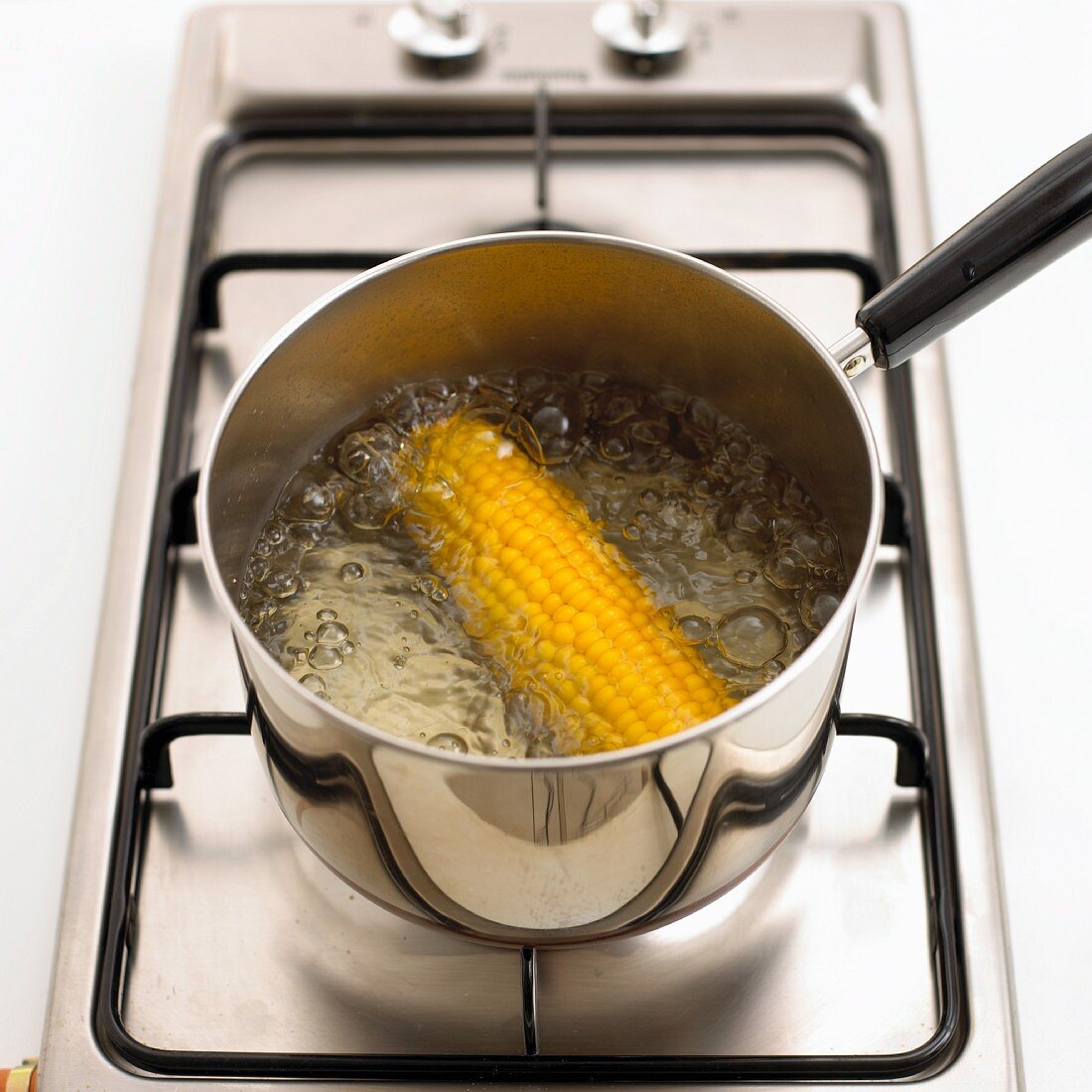 A corn cob being boiled