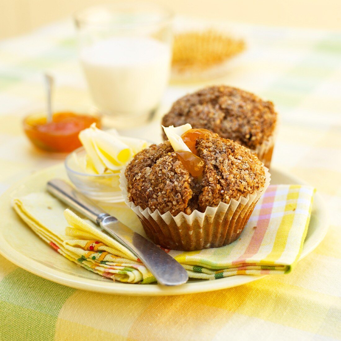 A breakfast muffin with butter and jam