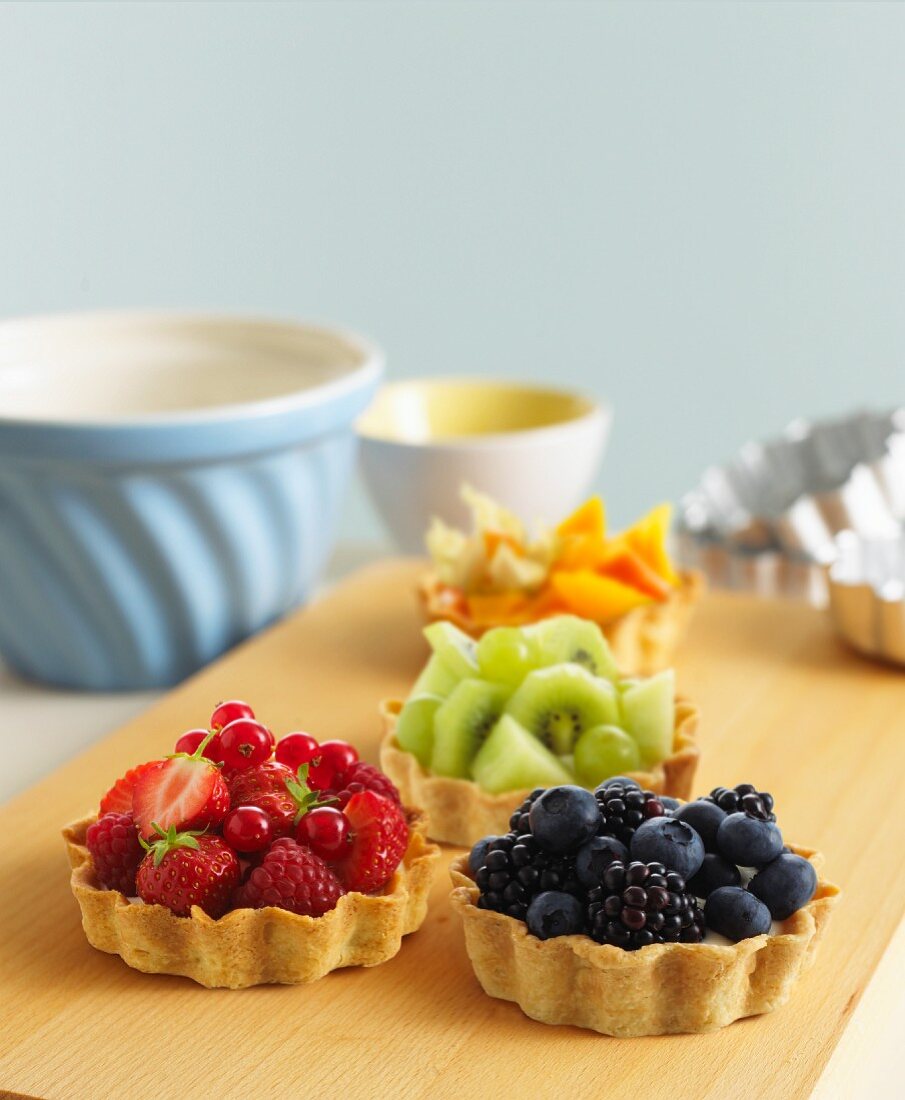 Various fruit tartlets on a chopping board