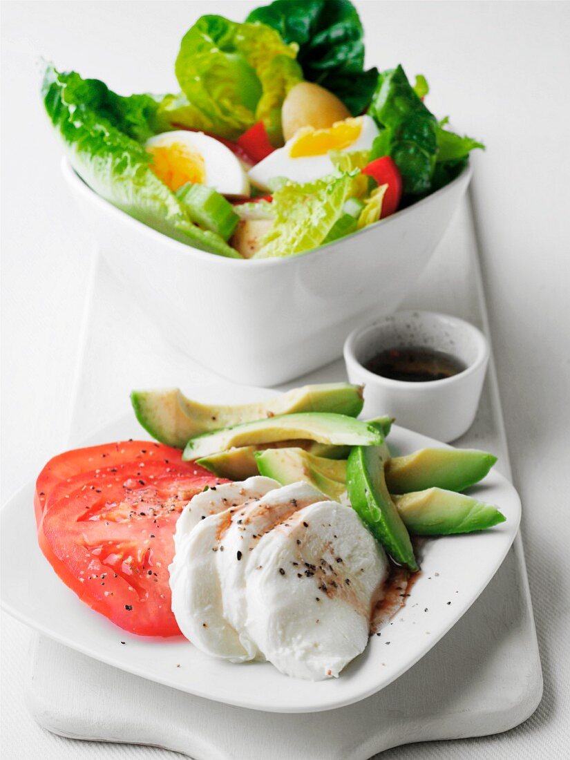 Tomatoes with mozzarella and avocado and a mixed leaf salad with egg