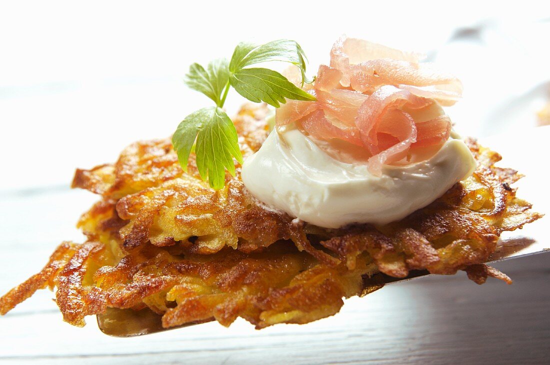 Potato rösti (hash brown) with sour cream and smoked ham