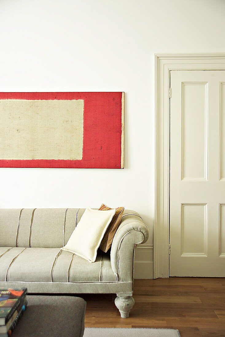 Detail of antique sofa and modern picture on wall