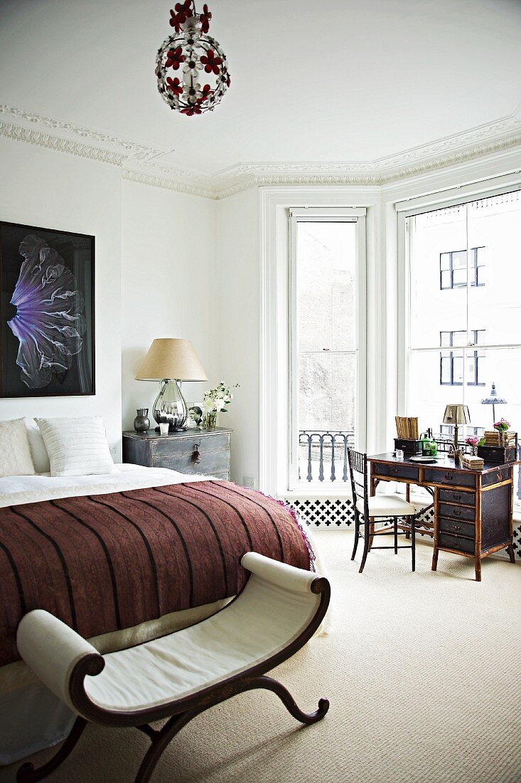 Grand bedroom with bed bench at foot of double bed and writing desk in front of window