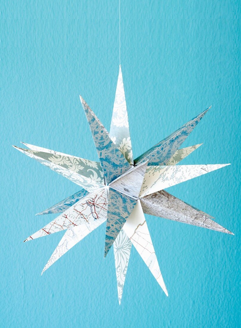 Christmas star hand made from paper printed with various patterns