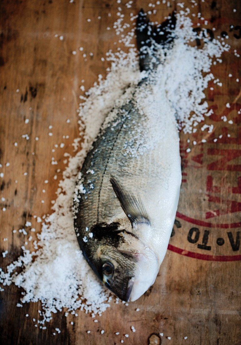 Fresh bream with sea salt on a wooden surface