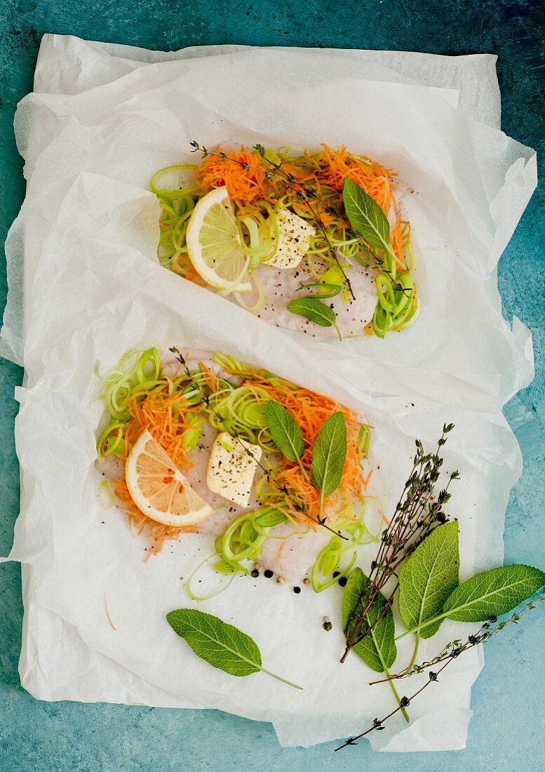 Fish fillet with vegetables and butter flakes in parchment paper
