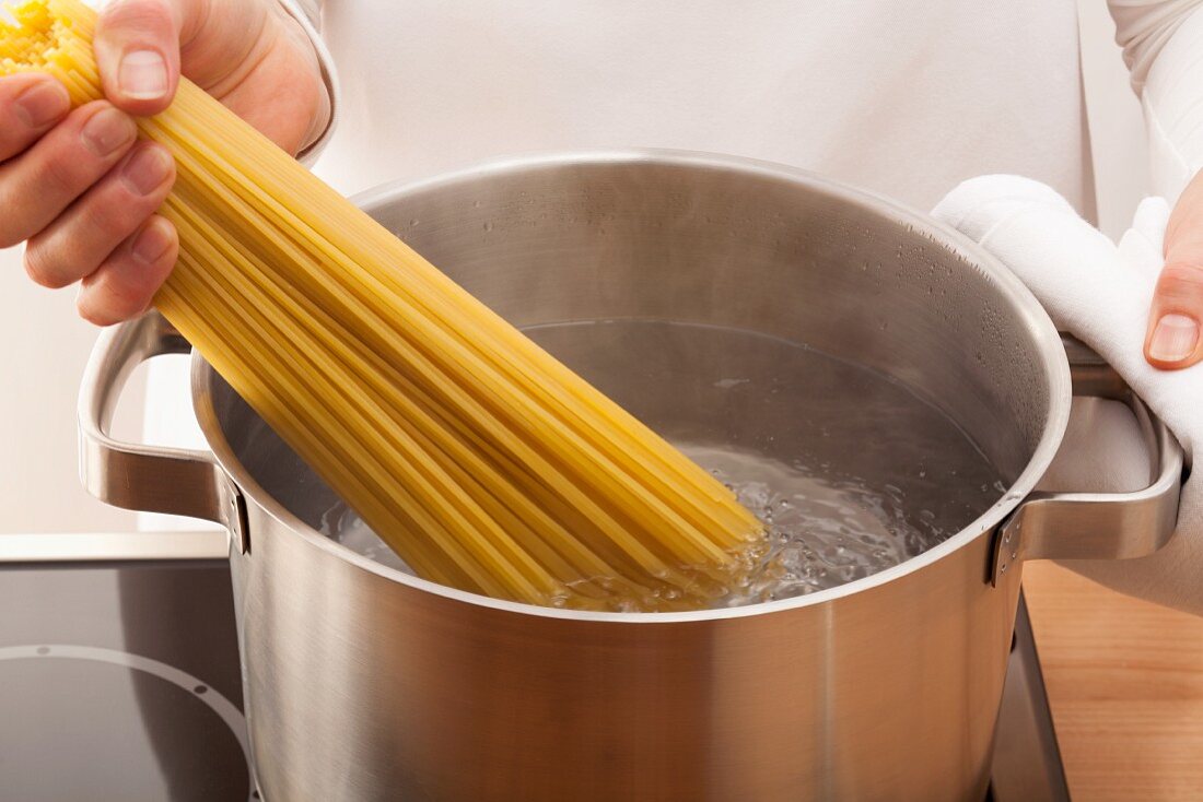Spaghetti ins kochende Wasser geben
