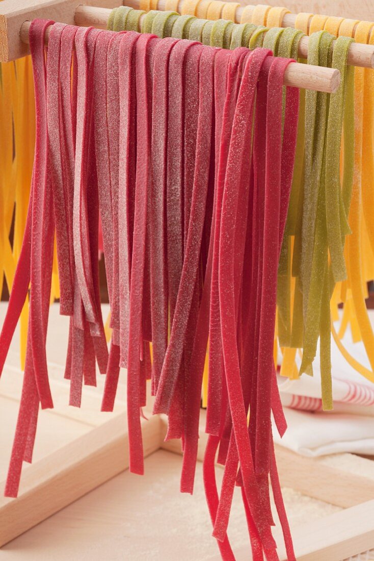 Colourful tagliatelle hanging to dry