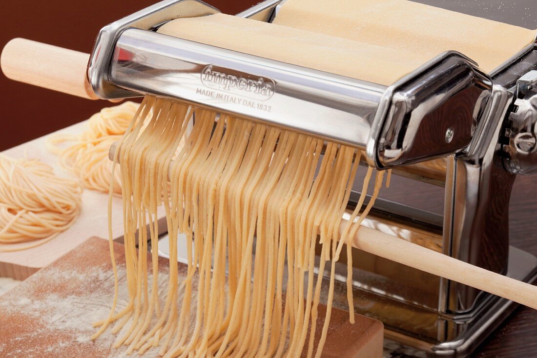 Nudelmaschine mit frisch geschnittenen Spaghetti