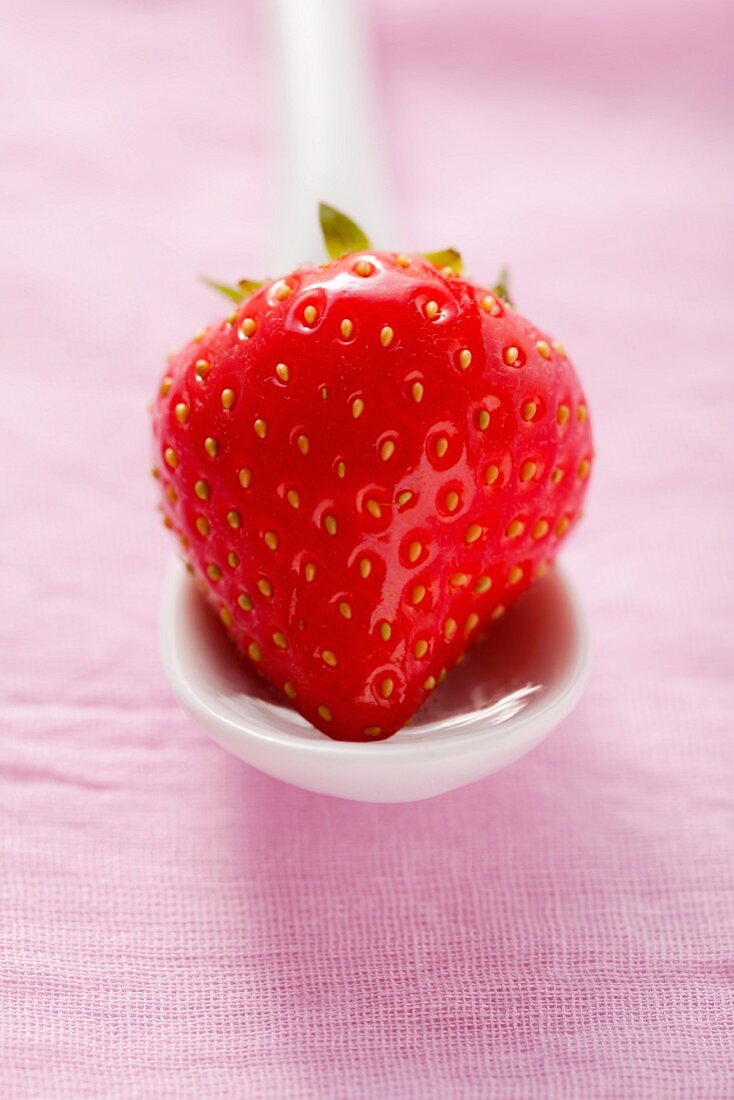 A strawberry on a ceramic spoon