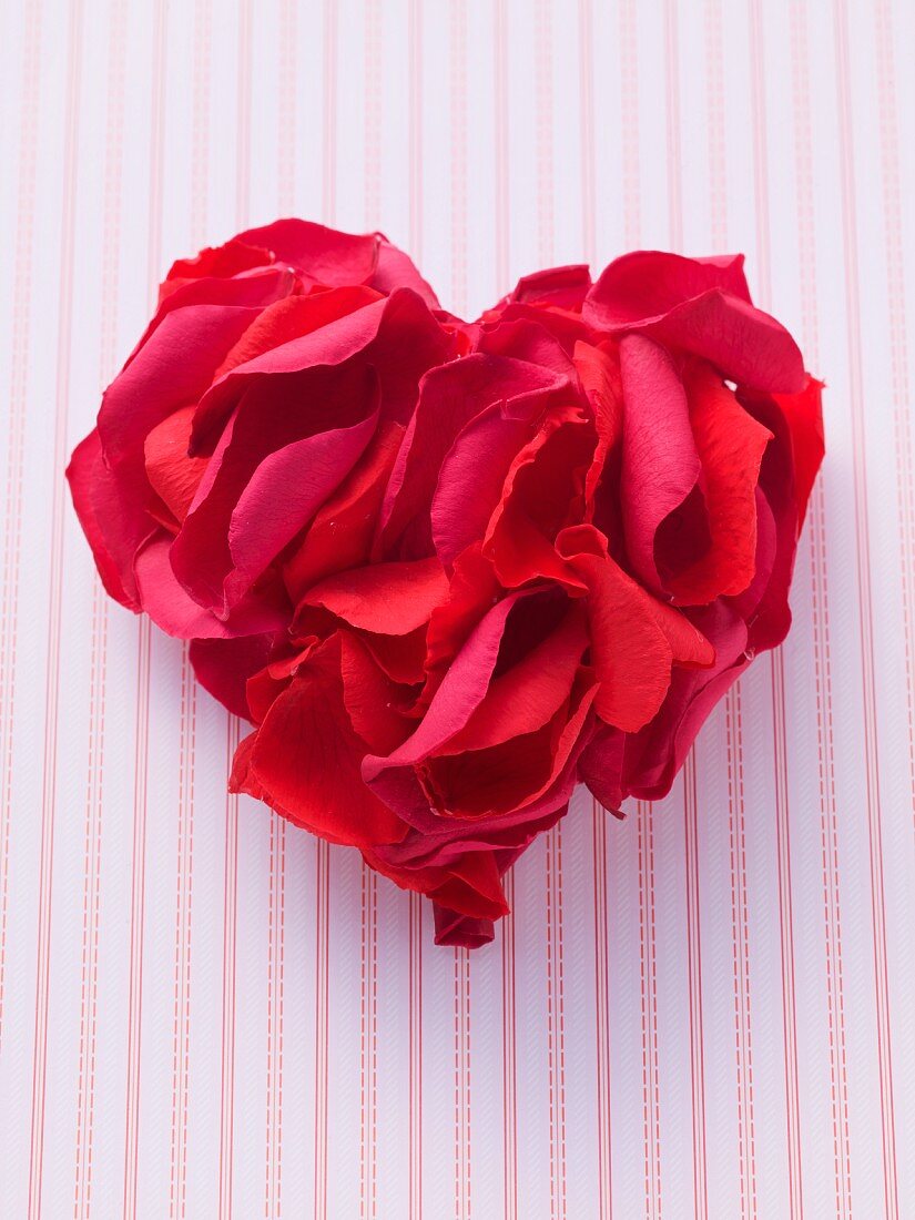 Red rose petals arranged in a heart shape