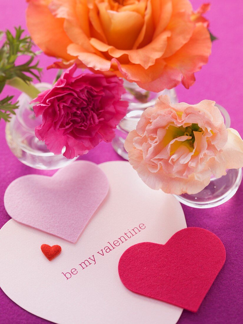 Herzdeko mit Valentinstagsspruch und Blumen