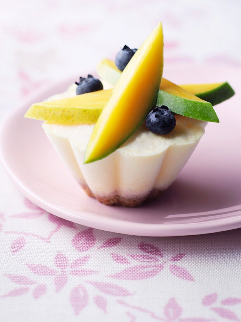 A mini cheesecake topped with fruits