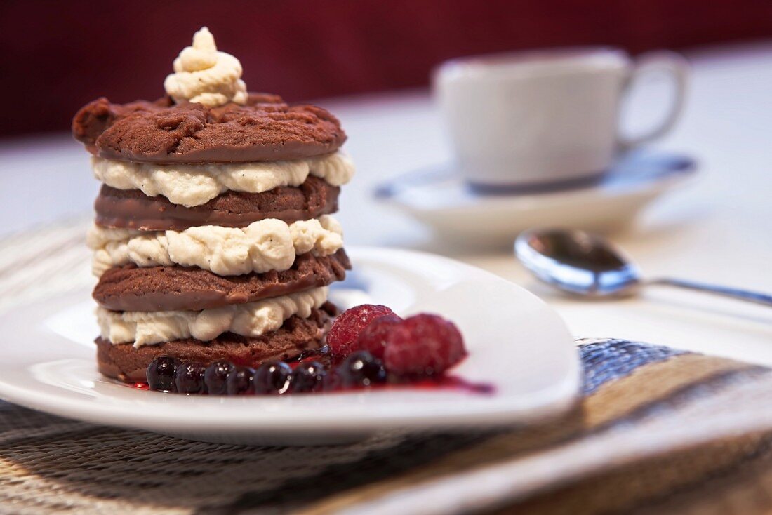 A tower of chocolate biscuits with mascarpone-marsala cream on berry sauce