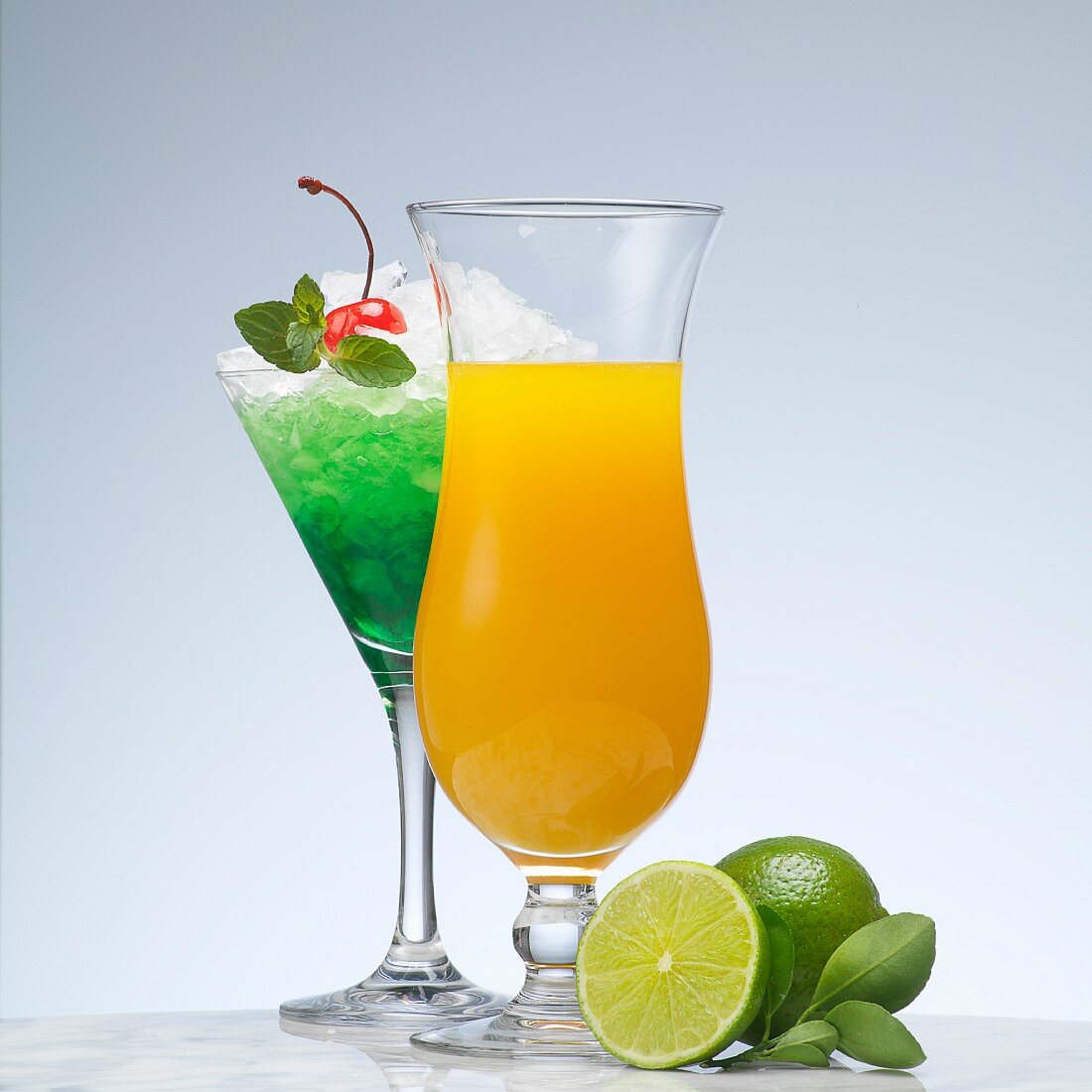 A green cocktail made with peppermint liqueur and a yellow cocktail made with vodka