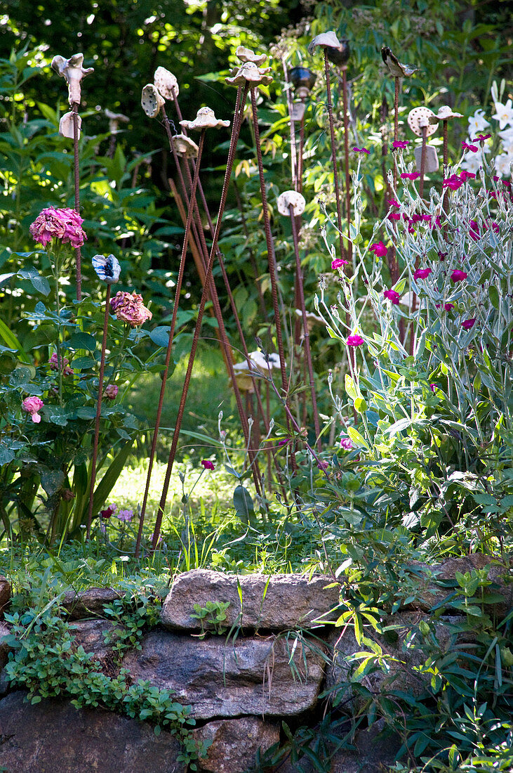 Blooming flowers above a natural stone wall