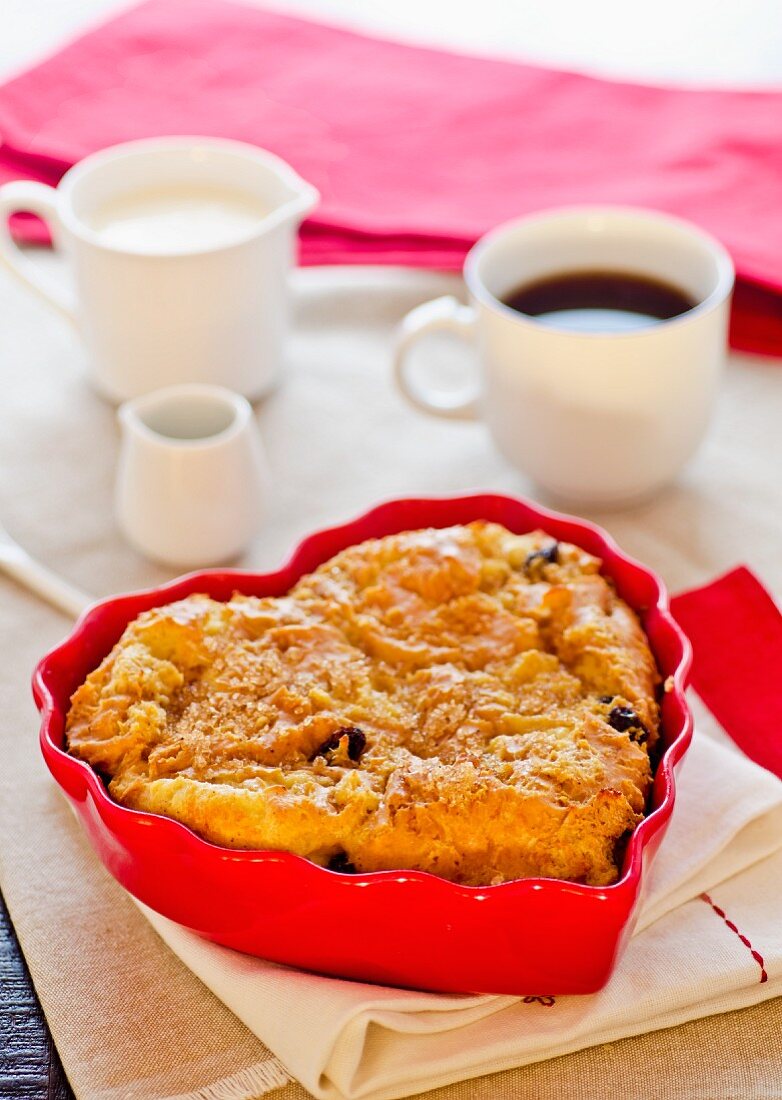 A heart-shaped apple cake with raisins and a cup of coffee