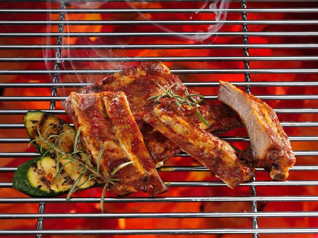 Spare ribs on a grill with vegetables