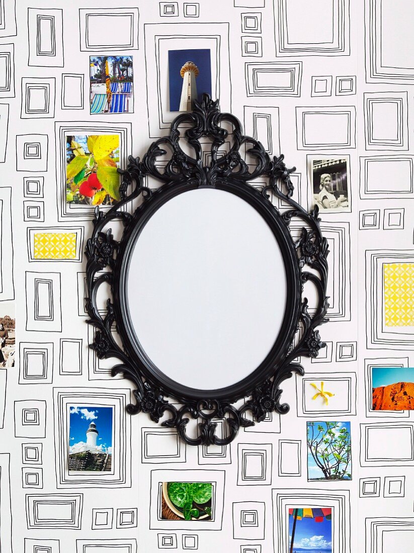 Mirror with black, vintage metal frame on patterned wallpaper