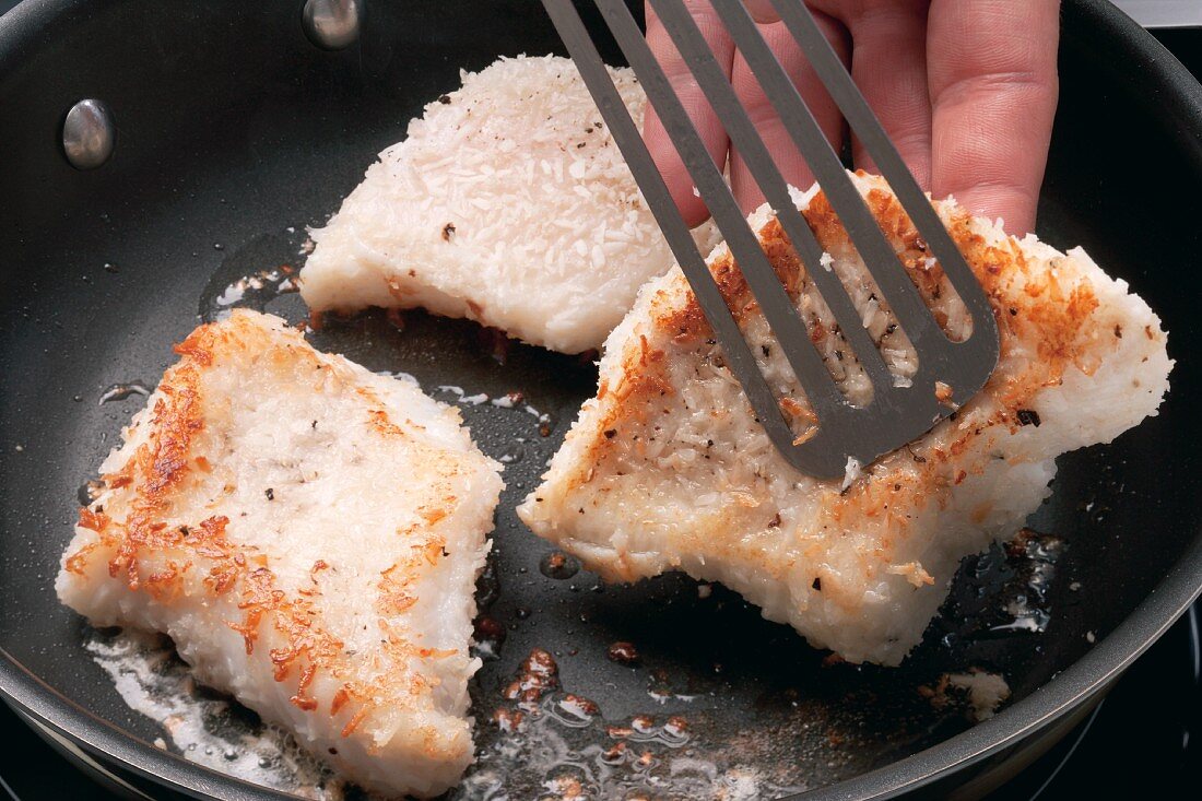 Catfish fillets with a coconut crust being fried