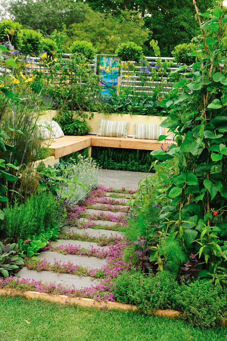 Secluded seating area in garden with wooden bench and cushions