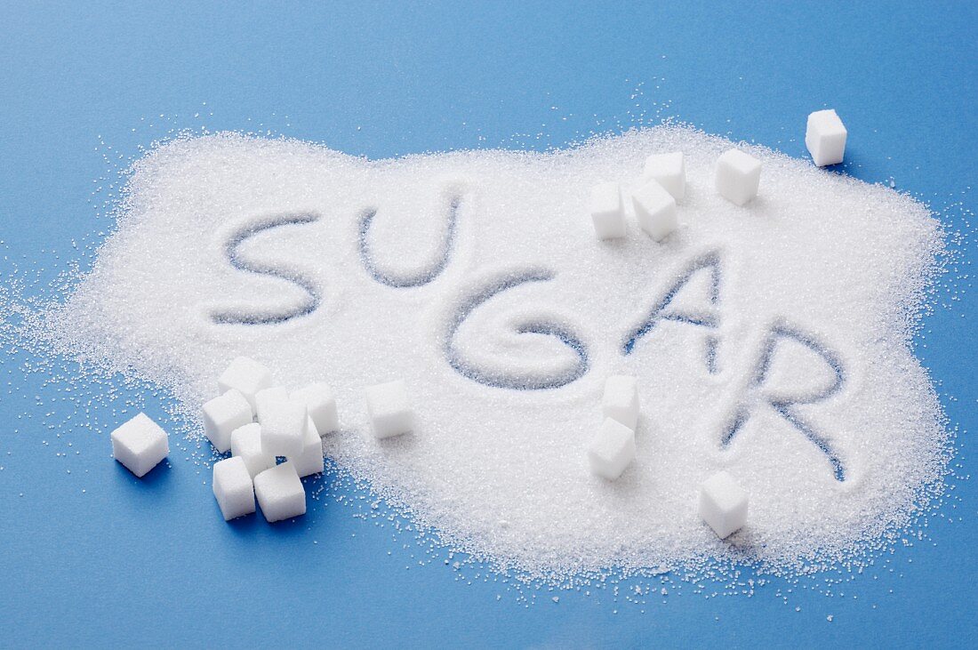 A pile of sugar with the word SUGAR written in it