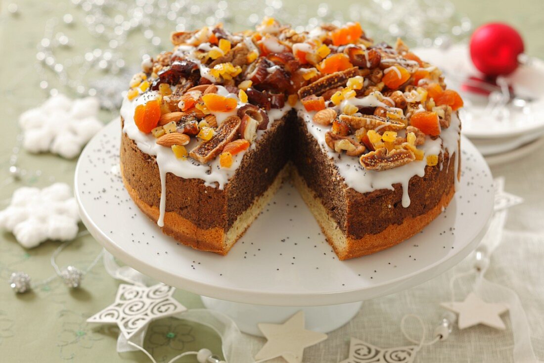 Poppy seed cake with icing, dried fruits and nuts for Christmas