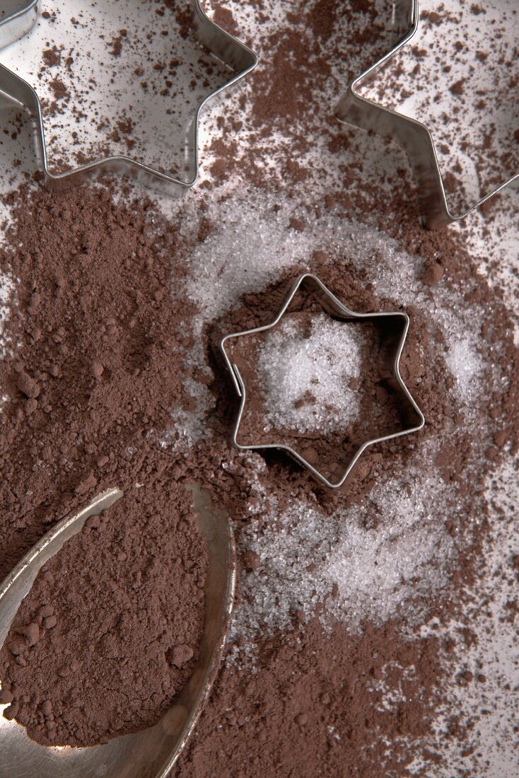 Kakaopulver auf Silberlöffel mit Zucker und Plätzchenformen