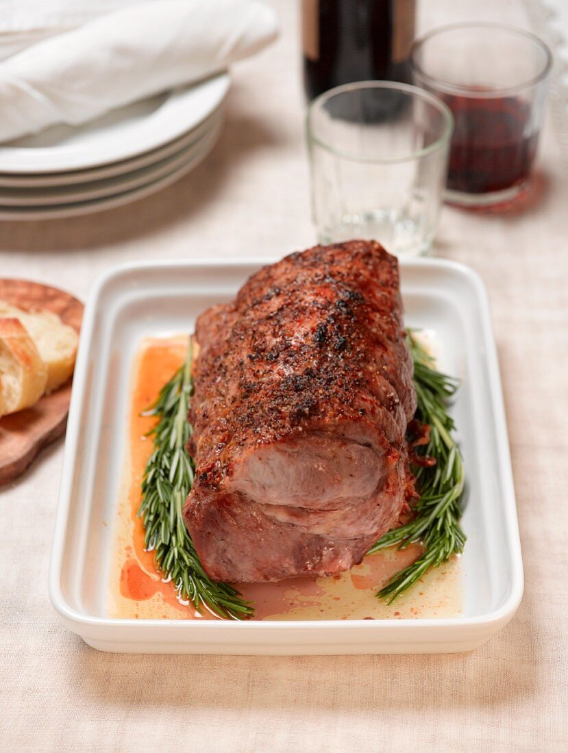 Roast pork with rosemary on a white platter