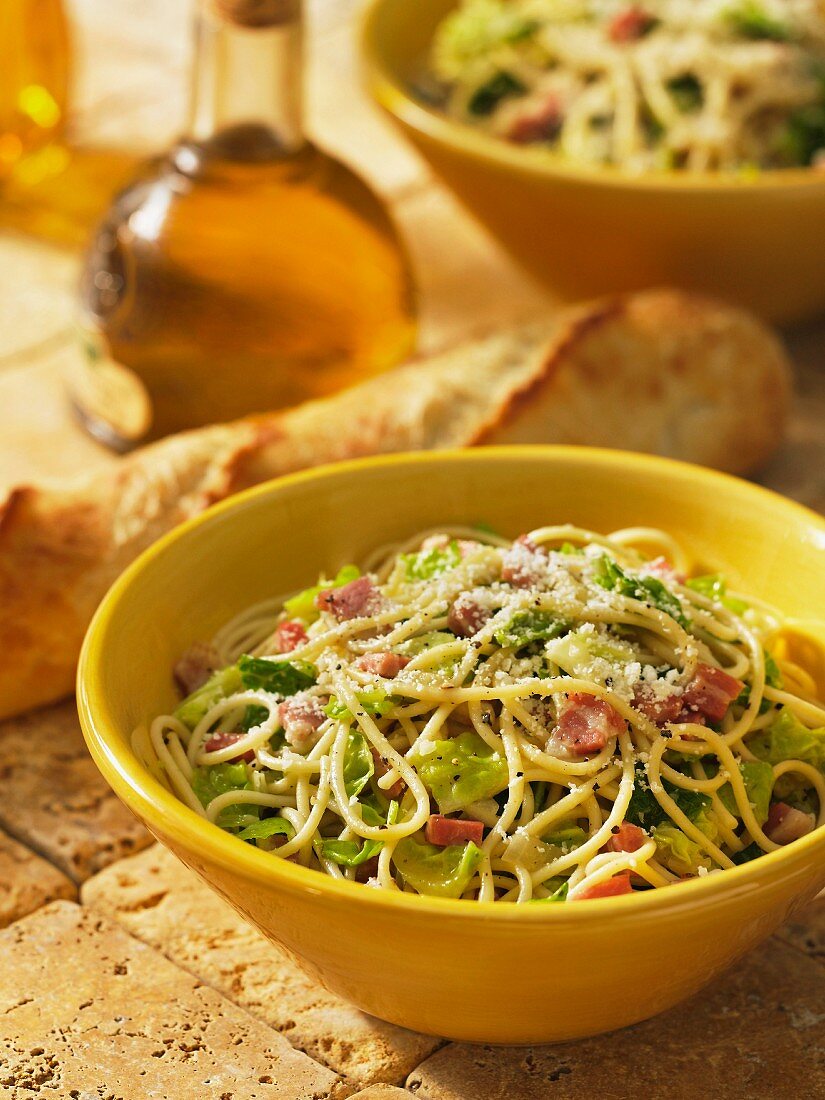Spaghetti with savoy cabbage and pancetta, baguette and olive oil