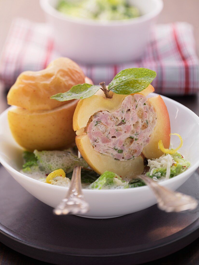 Baked apples filled with sausage meat on a bed of savoy cabbage with horseradish cream