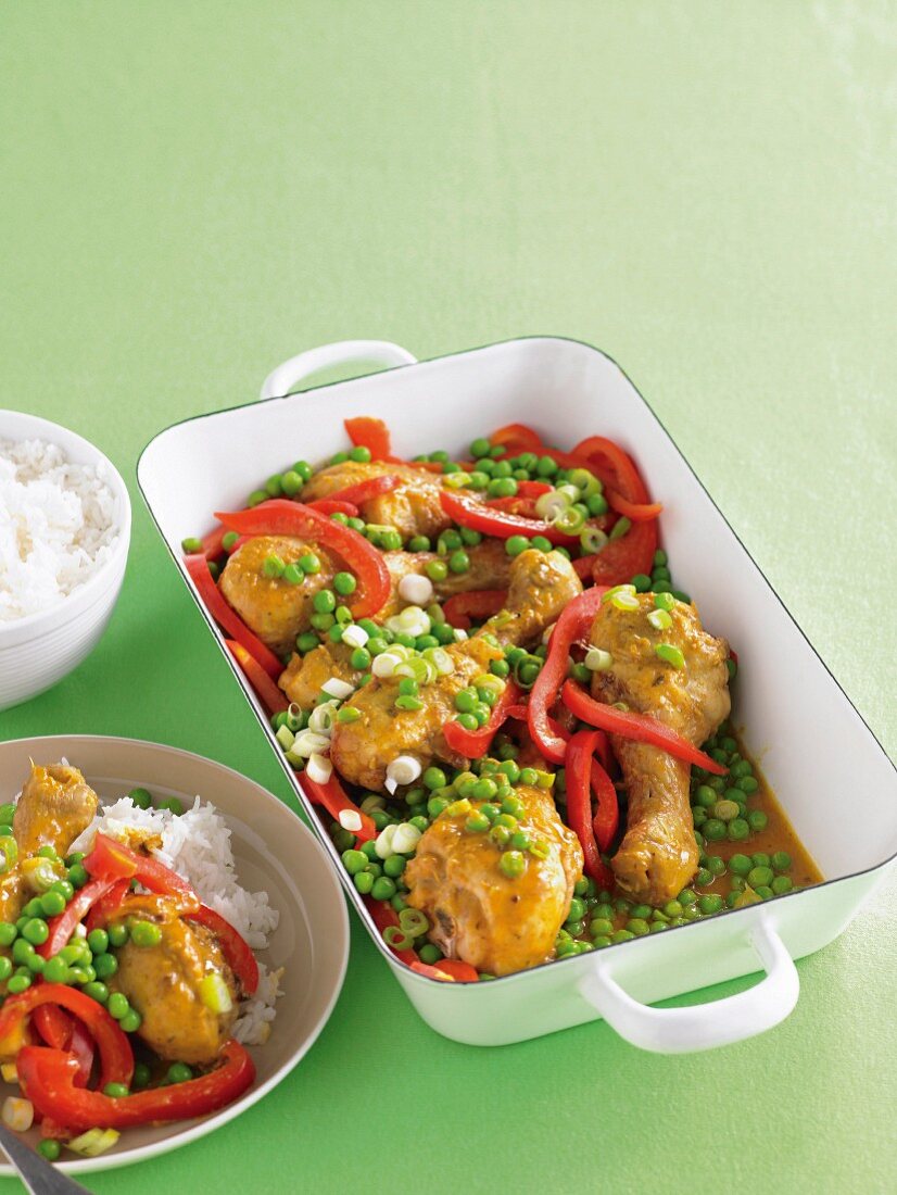 Chicken legs with peas and peppers in a coconut-curry sauce