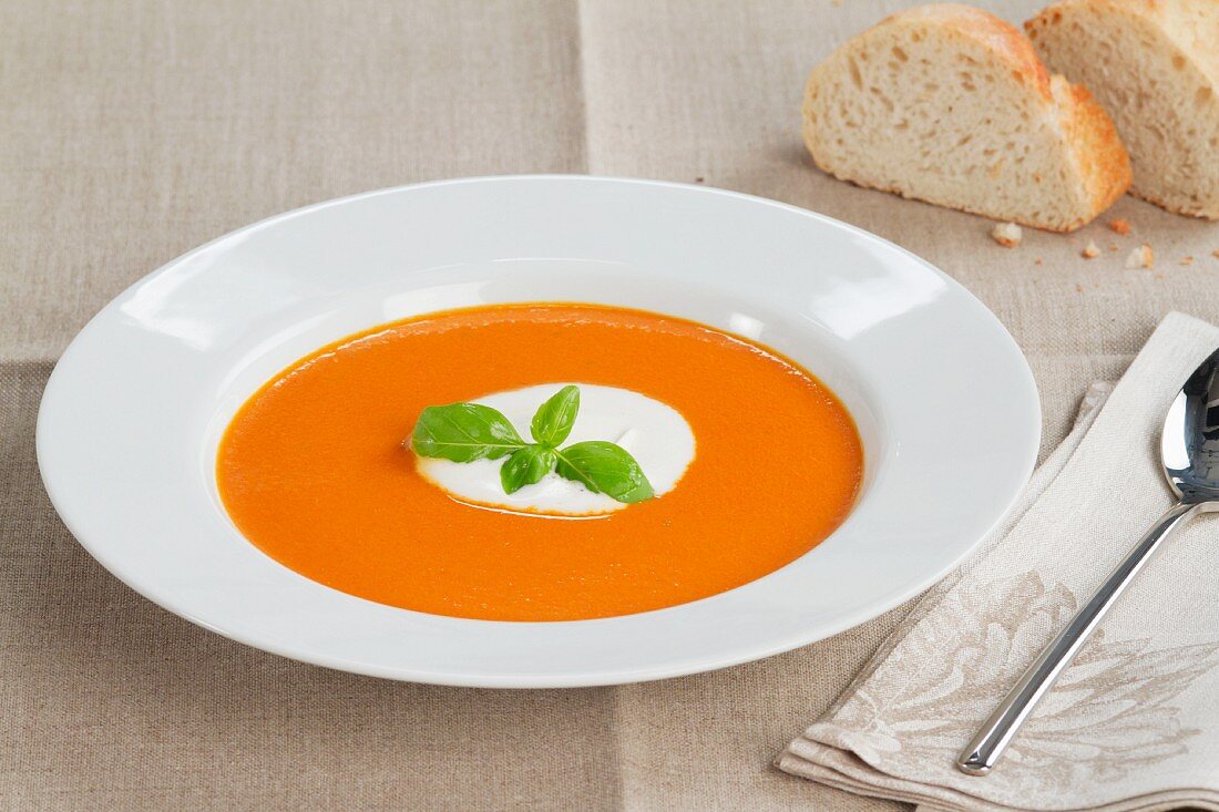 Cream of tomato soup garnished with a dollop of creme fraiche and basil