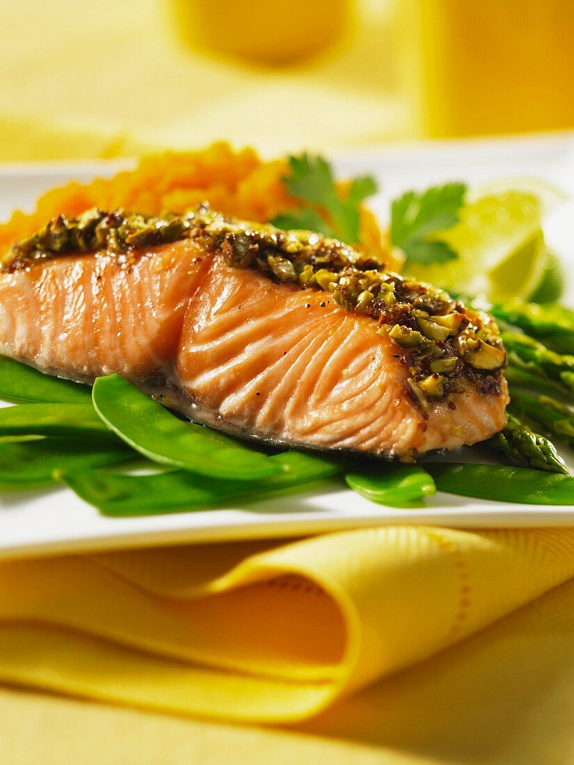 Salmon with a pistachio crust on a bed of mange tout and asparagus