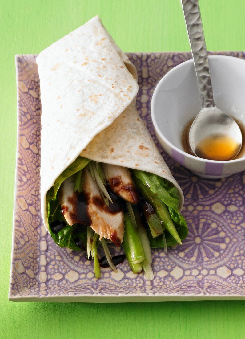 A wrap filled with chicken, spring onions and soy sauce