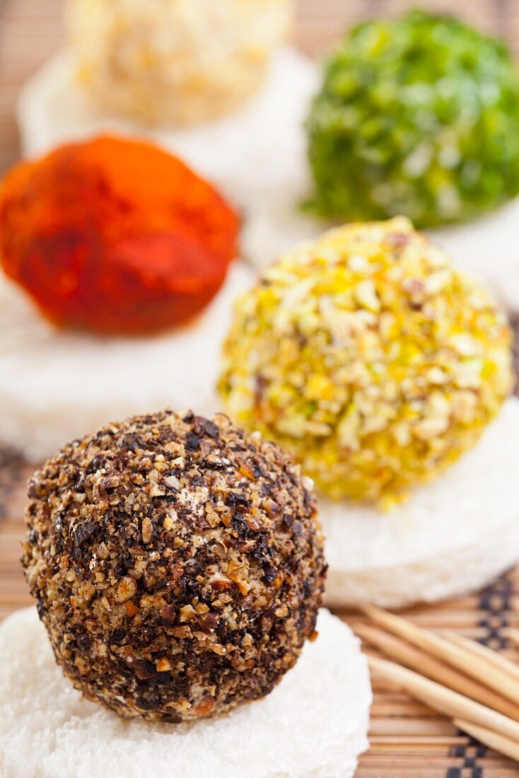 Cream cheese balled topped with pepper, pistachios, pepper, chives and walnuts