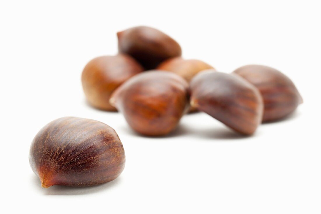 Edible chestnuts on a white surface