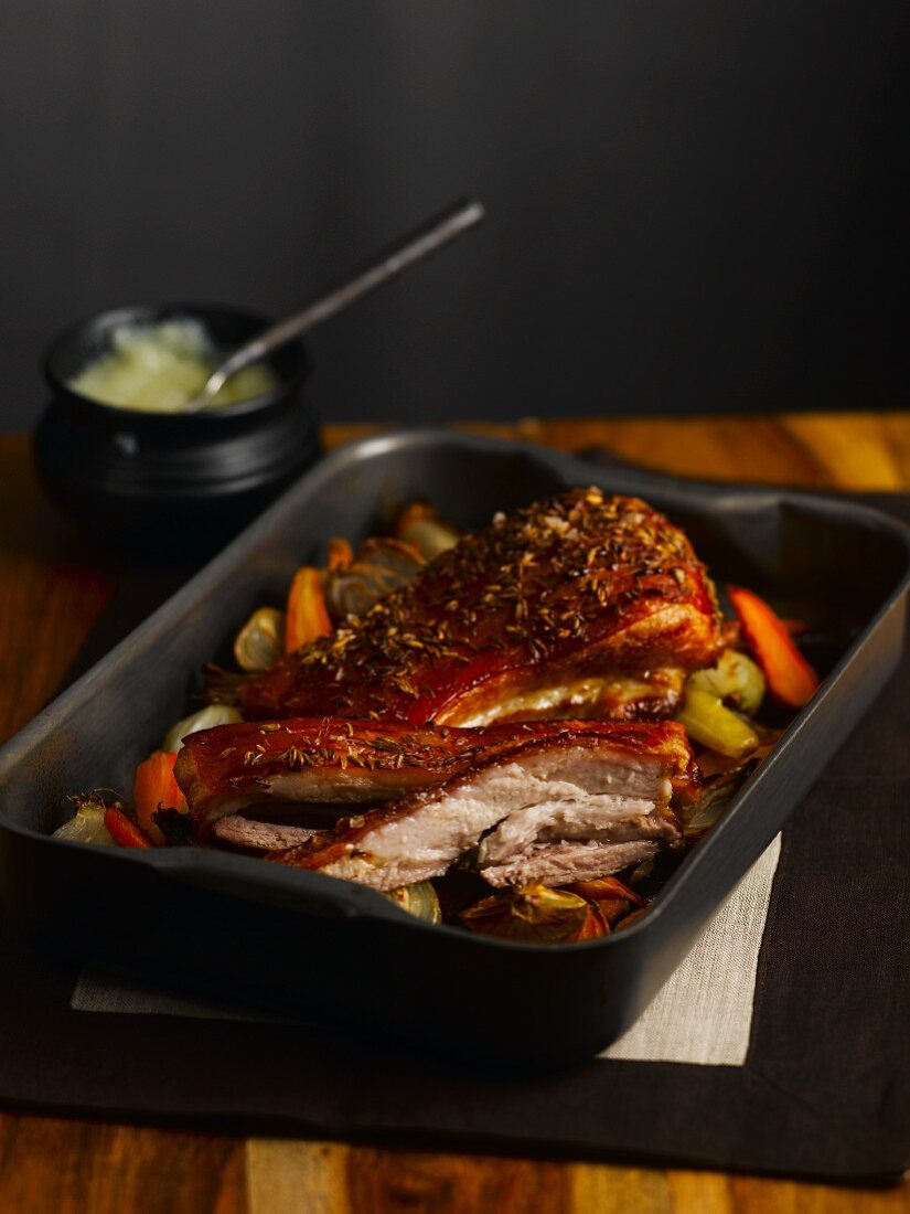 Crispy roasted pork belly in a roasting tin