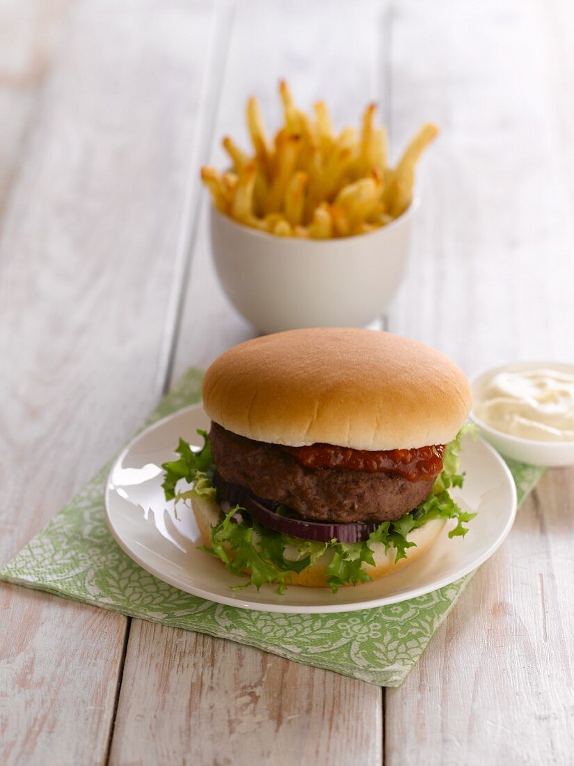 A hamburger with chips and mayonnaise