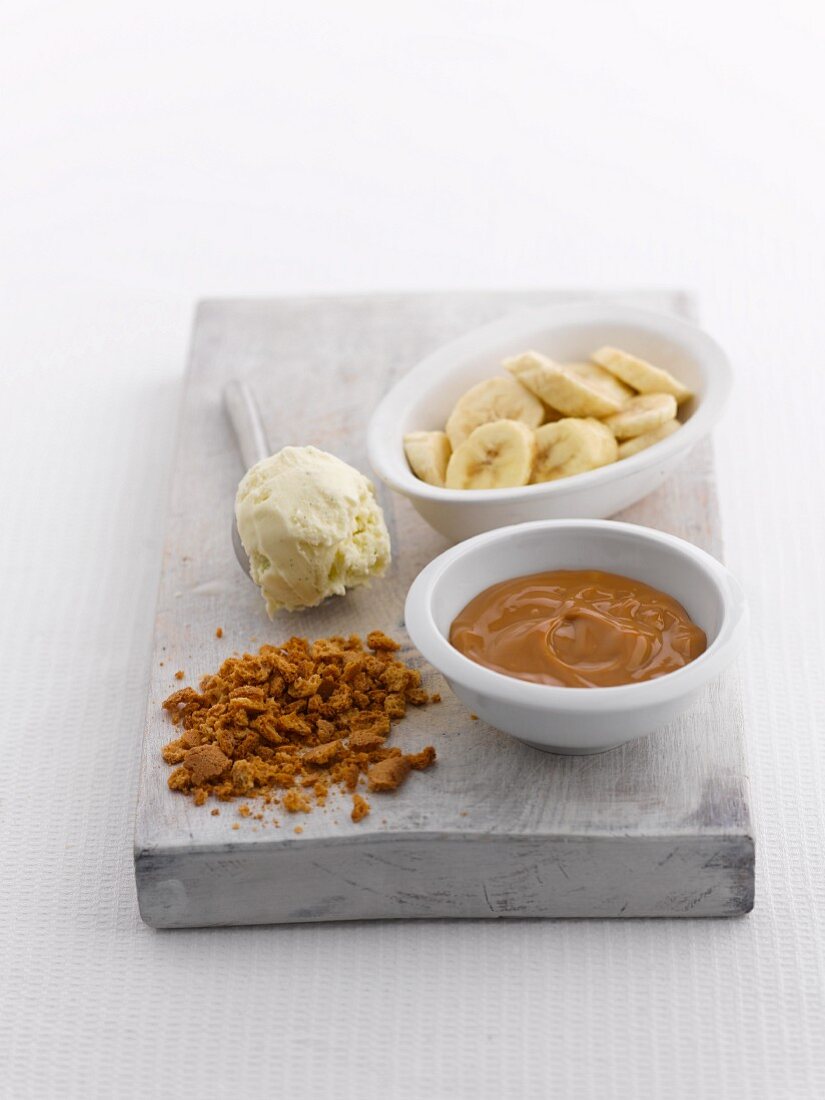 Ingredients for an ice cream sundae (vanilla ice cream, bananas, caramel)