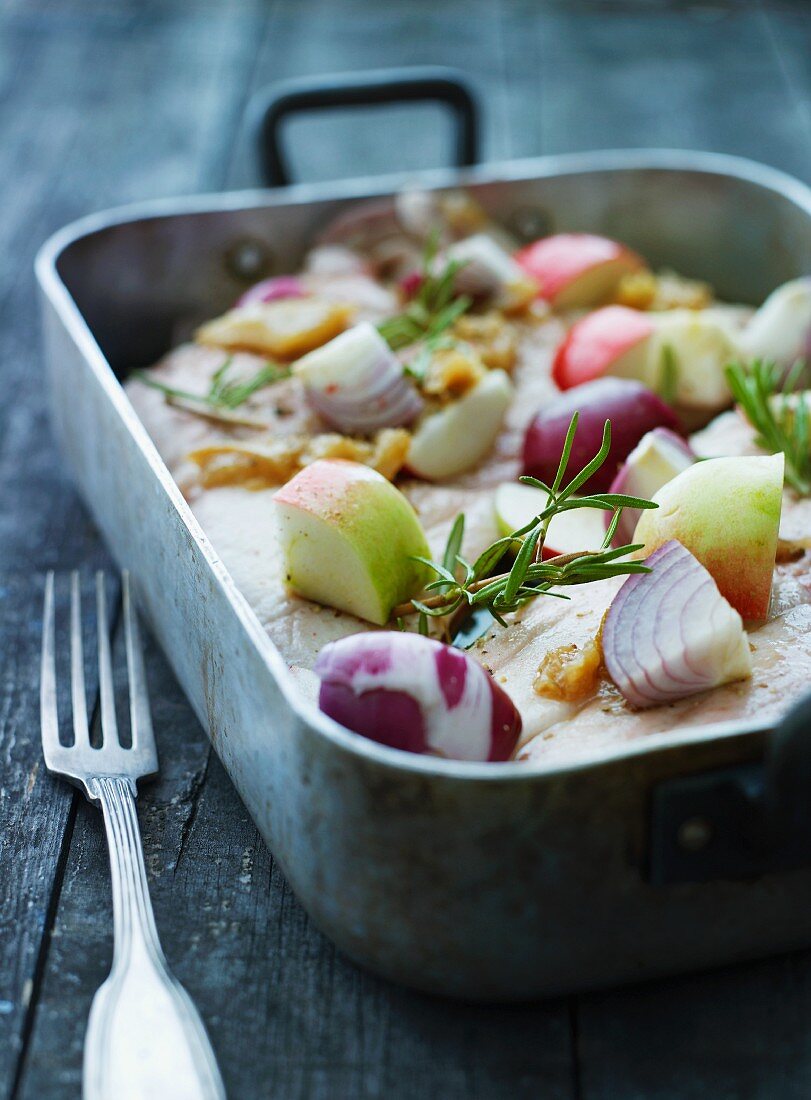 Pork belly with apples and onions ready for roasting