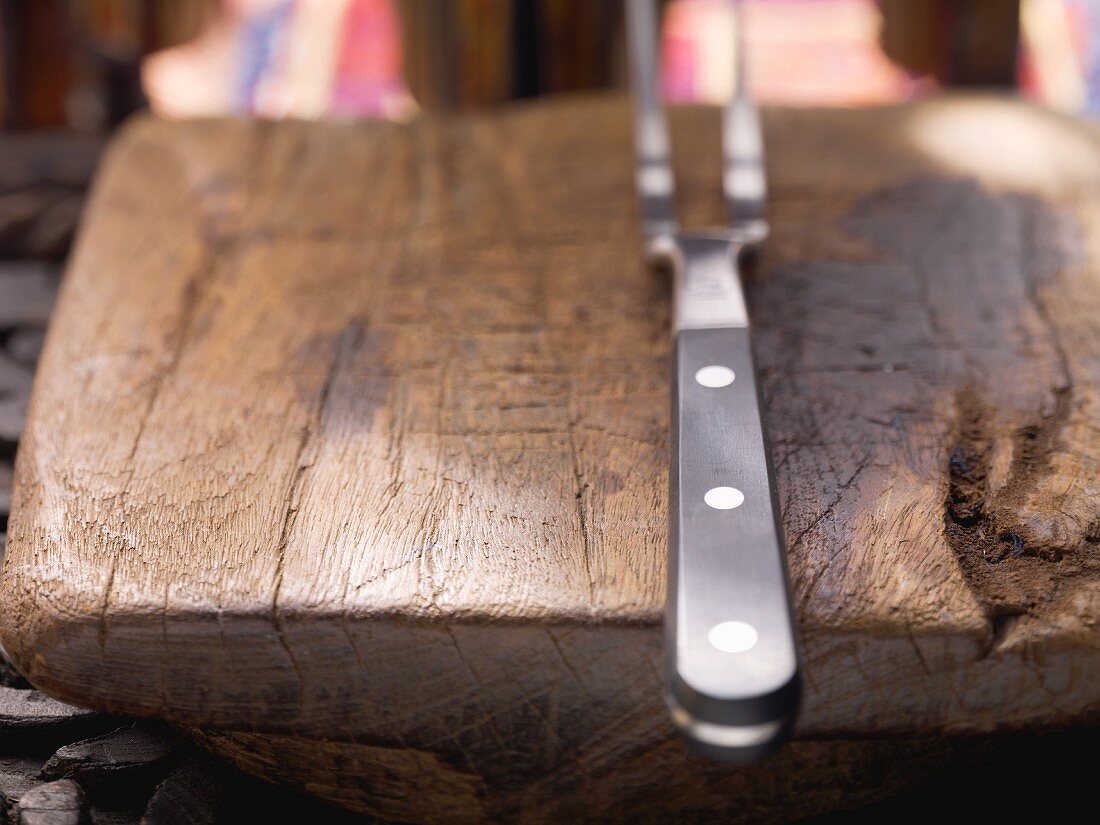 A carving fork on a wooden board