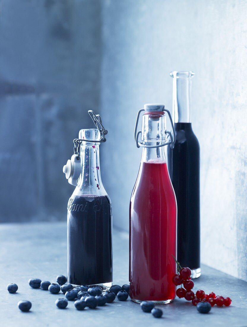 Homemade juices (blueberry juice and redcurrant juice) in flip-top bottles