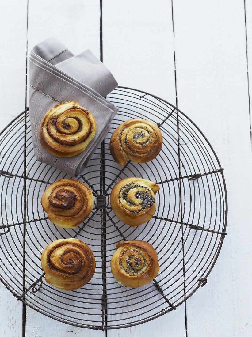 Cinnamon and poppy seed pastries on a wire rack