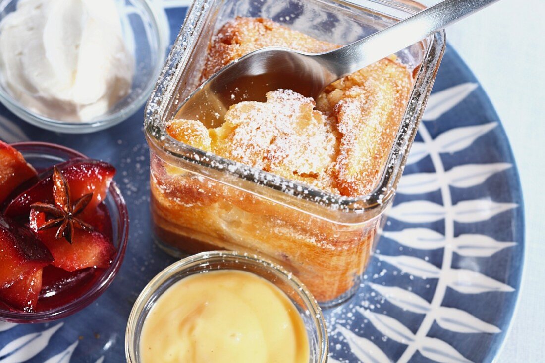 Kuchen im Glas mit Vanillesauce, Pflaumenkompott und Sahne