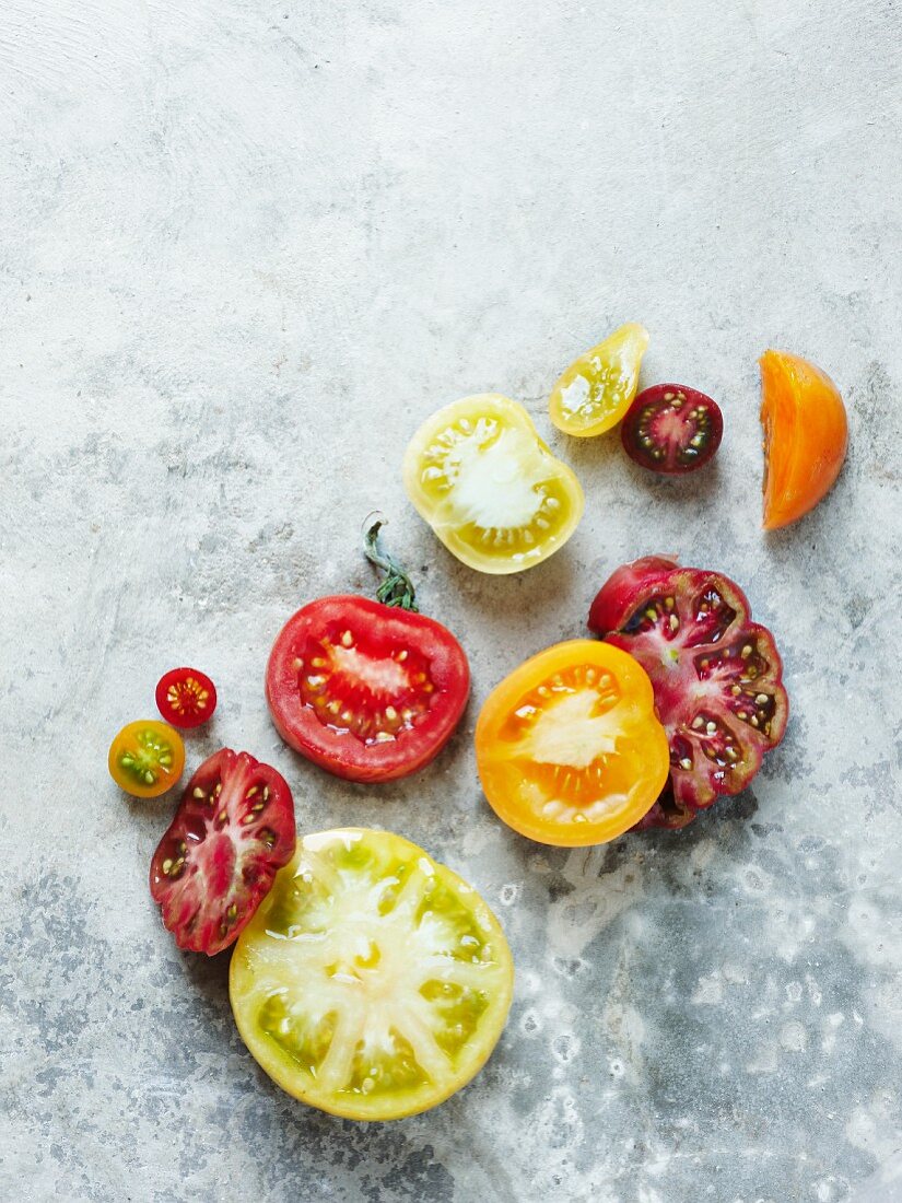 Verschiedene halbe Heirloom Tomaten auf Steinuntergrund