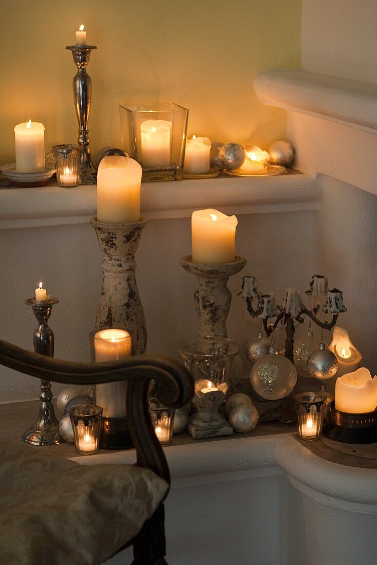 Verschiedene brennende Kerzen auf Kerzenständer in Zimmerecke