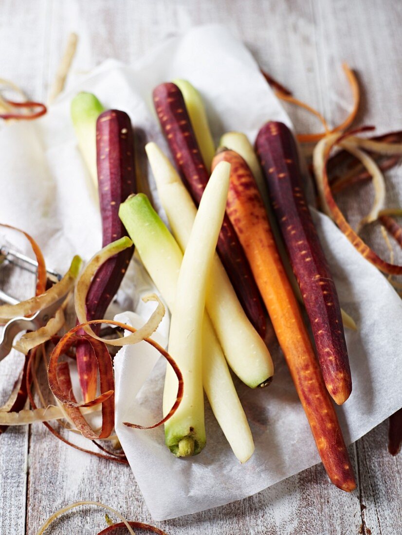 Various carrots (peeled) on a piece of paper