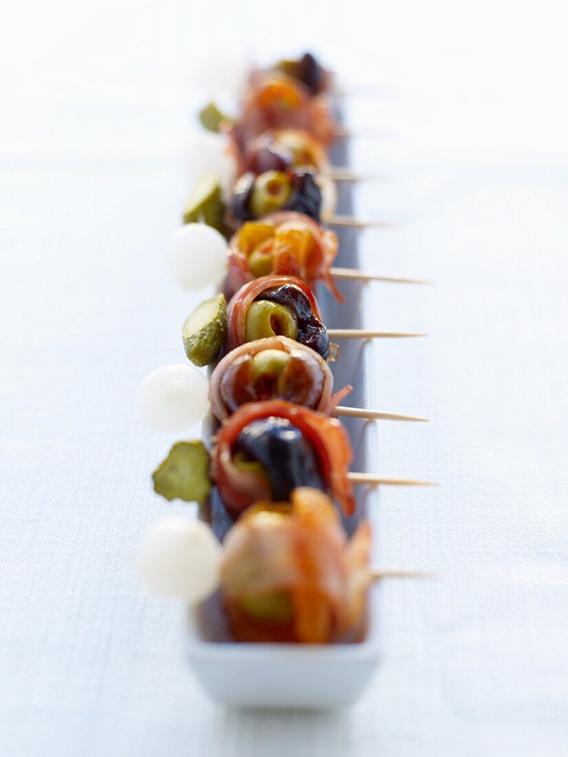 Olives, bacon and gherkins on sticks